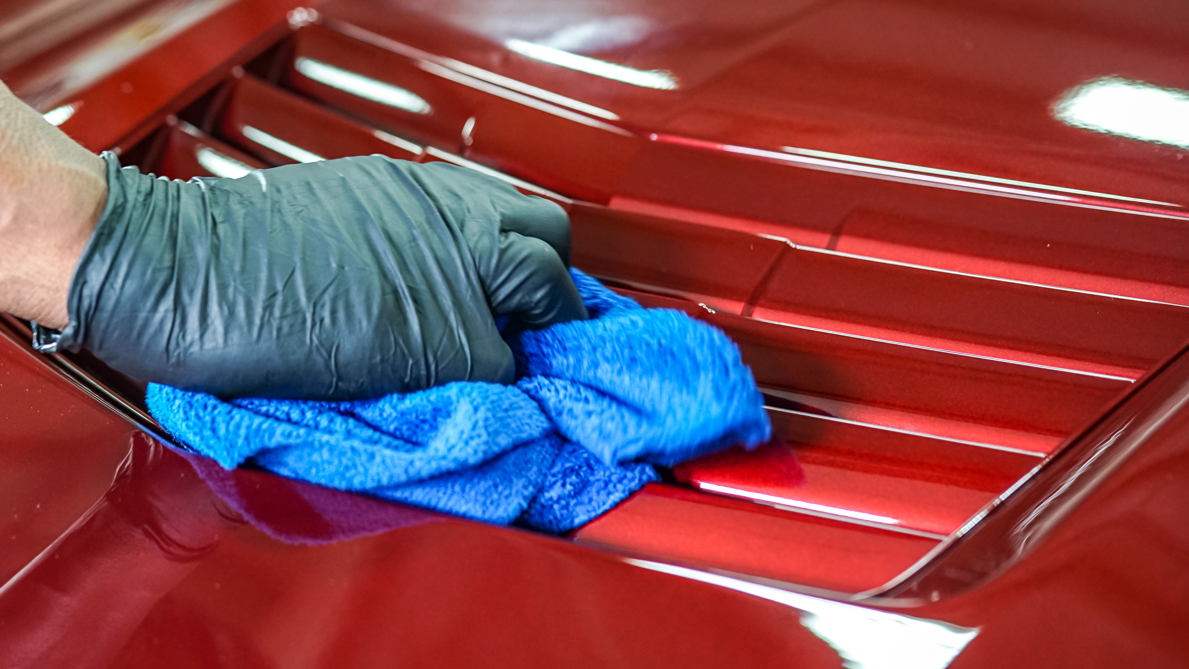 Red Corvette rear louvers being detailed to a perfect shine