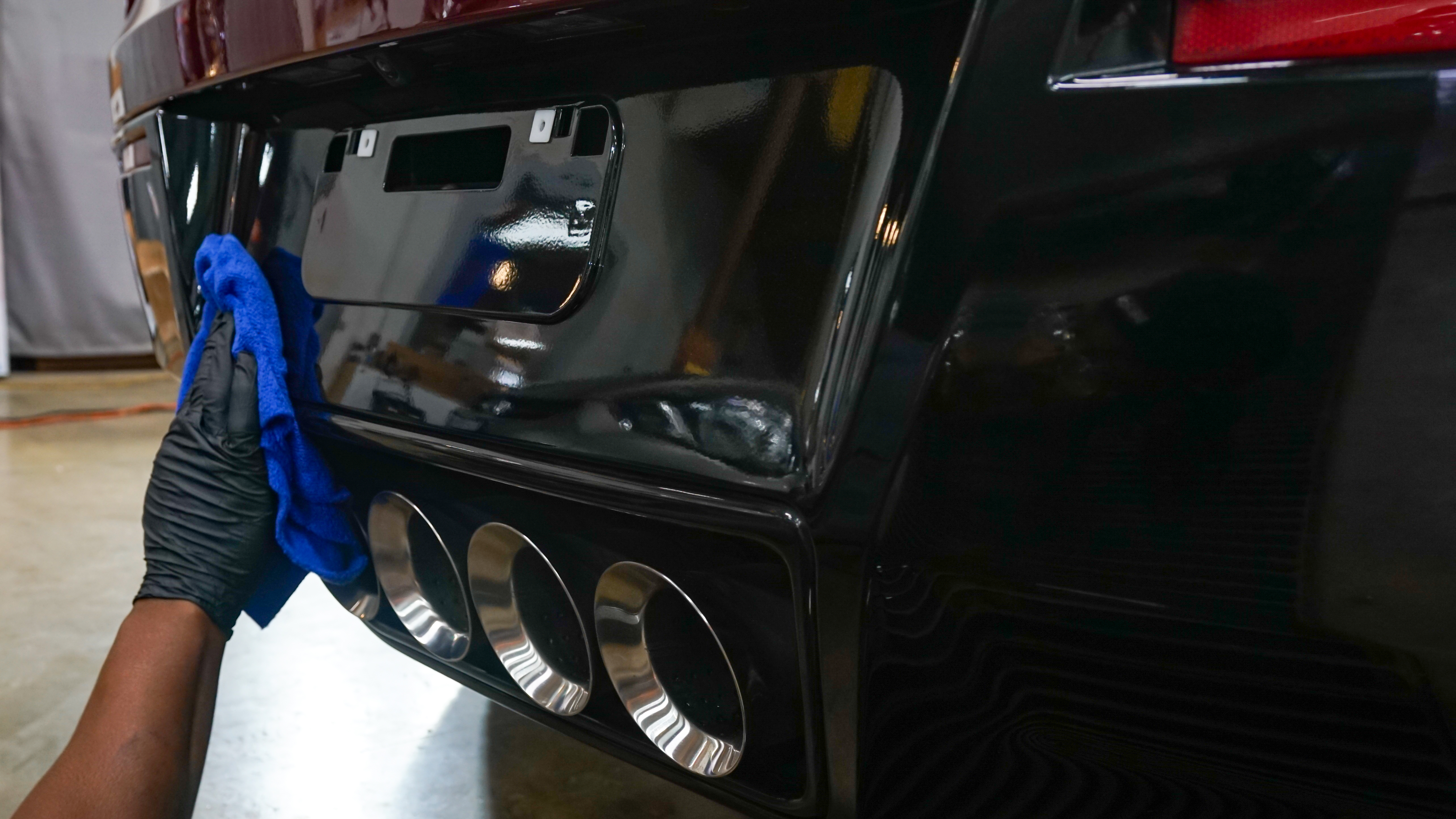 Black Corvette rear quad exhaust tips being detailed