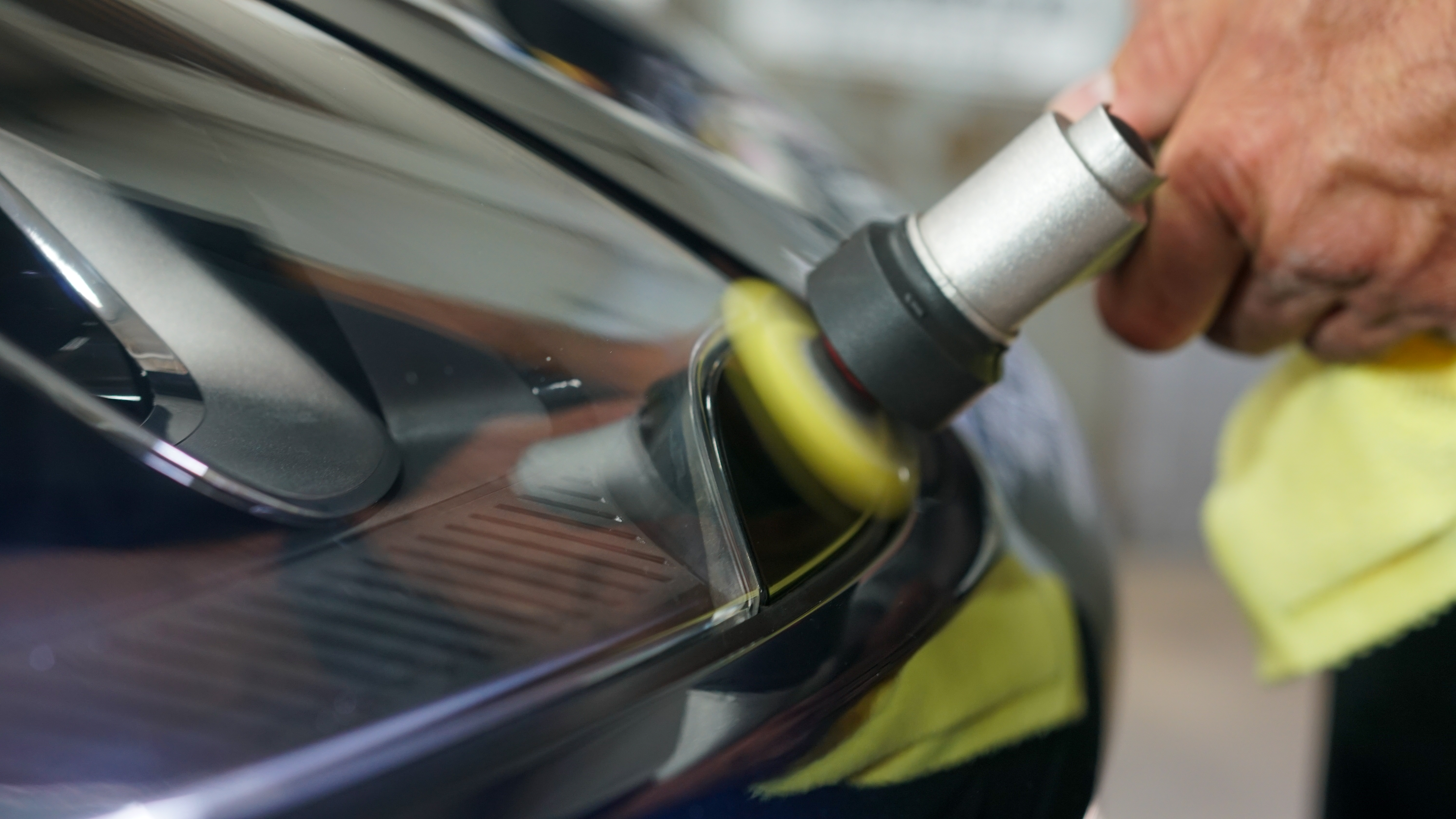 Ferrari badge with dramatic water spray during professional wash